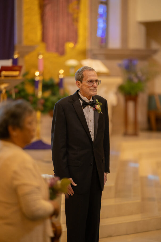 groom looking at his bride for the first time taken by Las Vegas catholic wedding photographer Alexis Dean