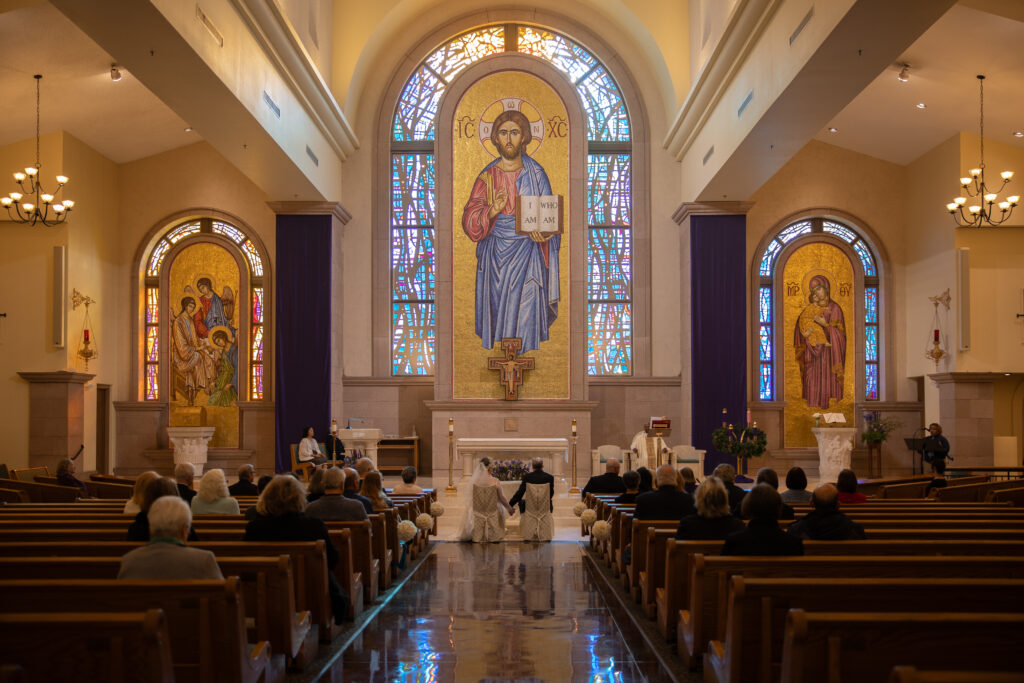 bride and groom holding hands during their wedding at st. Joseph, husband of Mary Catholic Church in Las Vegas, taken by Alexis Dean Photography