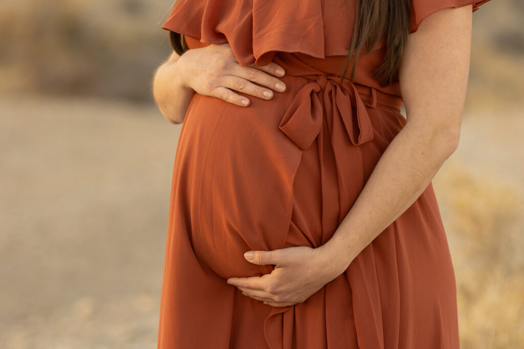 closeup photo of a baby bump with maternity photographer Alexis Dean Las Vegas Nevada in desert