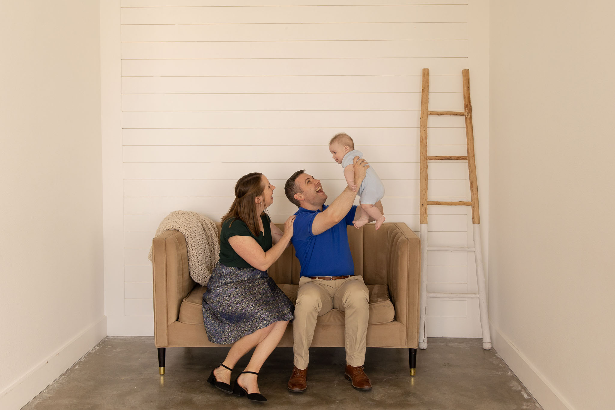 The Dean family sitting on a couch together at The Gathering Place during family headshots