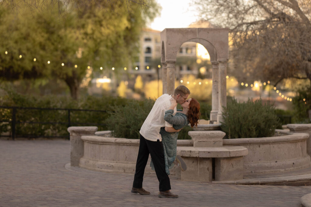 anniversary session with alexis dean photography at lake las vegas couple doing a dip and kissing near the lake