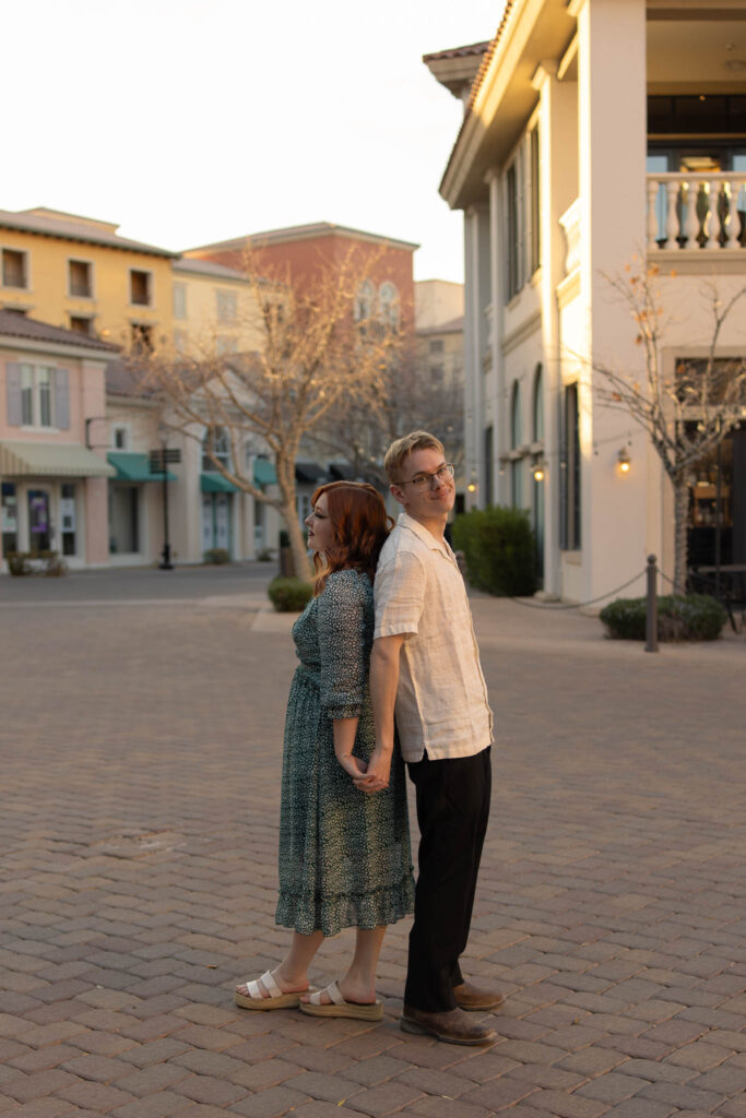 husband and wife standing back to back at sunset lake las vegas