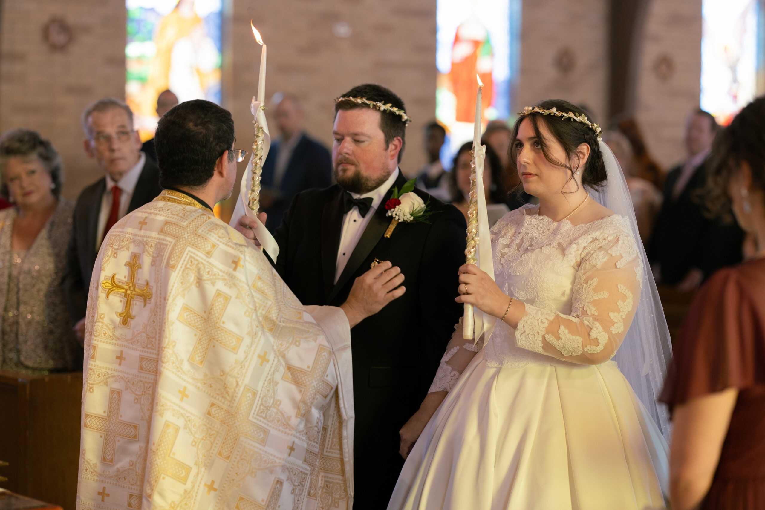 bride and groom holding candles during the mystery of crowning (wedding ceremony) at Three Hierarchs Byzantine Catholic Church in San Antonio